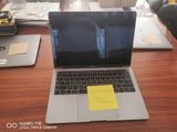 a laptop computer sitting on a desk with a sticky note on the screen