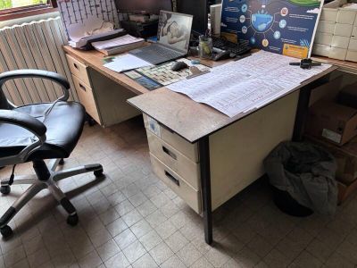 un bureau avec un ordinateur et une chaise dans une pièce