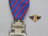 une médaille d'argent accompagnée d'un ruban bleu et rouge et d'un petit insigne