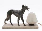 statue of a dog with a lamp on a marble base