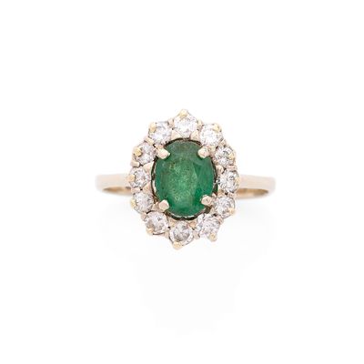 une bague ovale sertie d'une émeraude et d'un ensemble de diamants