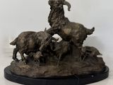 statue représentant une chèvre et trois chèvres sur un rocher, sur fond blanc