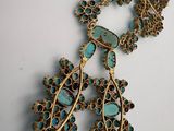 a close up of a necklace and earrings on a table