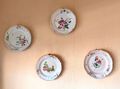 trois assiettes ornées de fleurs, accrochées au mur