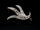a close up of a diamond broochle on a black surface