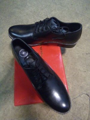 pair of black shoes on a red box on the floor