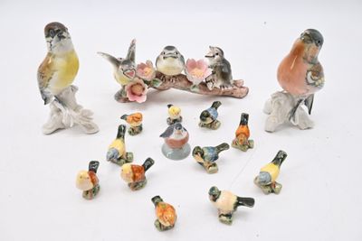 many figurines of birds sitting on a white surface