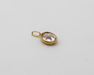 un pendentif plaqué or orné d'un quartz transparent au centre