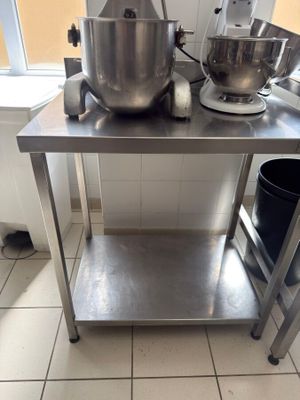 a stainless steel table with a mixer on top of it