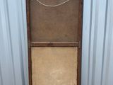 an old wooden cabinet with a metal door on a gravel ground