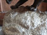 a statue of a dog that is on a rock