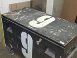 une boîte noire portant un numéro, posée dans un garage