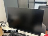 une photo d'un bureau d'ordinateur avec un écran et un clavier