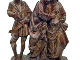 statue représentant deux hommes assis sur un banc avec un chien