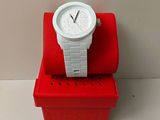 une montre blanche posée sur une boîte rouge