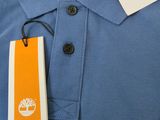 polo shirt with a tree on the front and a tag on the back