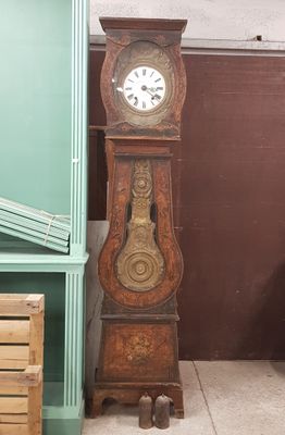 une horloge de parquet posée dans un coin d'une pièce