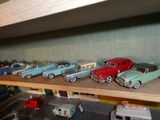 Des petites voitures sont alignées sur une étagère dans un magasin de jouets