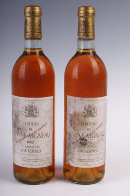 two bottles of wine sitting next to each other on a white surface