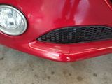 a close up of a red car parked in a garage