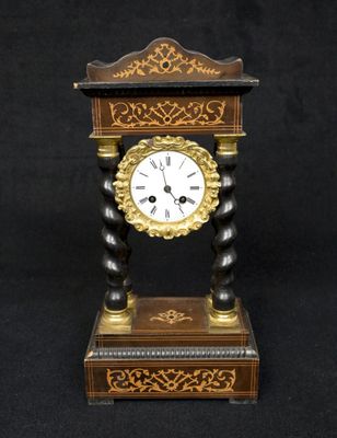 une horloge posée sur un socle, sur fond noir
