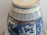 a blue and white vase on display on a clear shelf