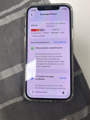 iPhone X avec les notifications affichées à l'écran, posé sur un lit