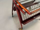 a wooden and glass trolley with a basket on it
