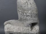 statue of a seated man on a stone base on a black background