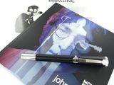 un stylo posé sur un livre orné d'une photo de John Lennon