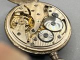 a close up of a pocket watch on a table