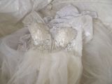 a wedding dress that is laying on a bed