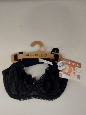 La bralette noire est suspendue à un cintre accroché au mur.