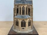 a small model of a building on a wooden table