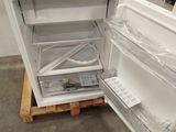 an open refrigerator sitting on a pallet in a room