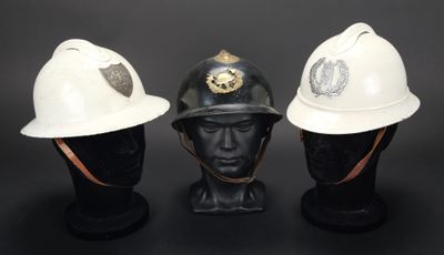 trois casques de pompier blancs posés les uns à côté des autres sur une tête de mannequin