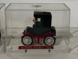 a small toy car in a clear box on a white surface