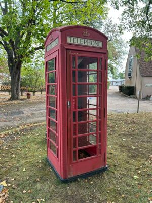 une cabine téléphonique rouge au milieu d'un champ