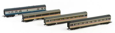 four model trains are lined up in a row on a white surface