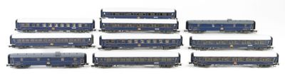 six blue train cars sitting next to each other on a white surface