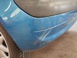 a close up of a blue car with a denting on it