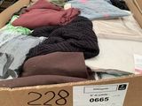 a cardboard box filled with lots of clothes in a store