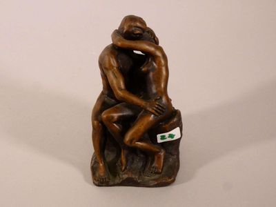 une figurine représentant un homme et une femme assis sur un rocher