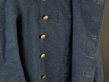a blue coat with gold buttons on a mannequin head