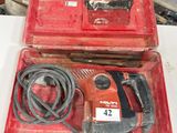 une boîte à outils rouge contenant une perceuse filaire