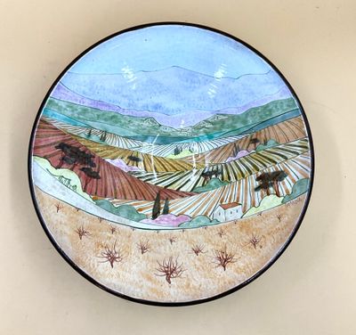 une assiette sur laquelle est représenté un paysage
