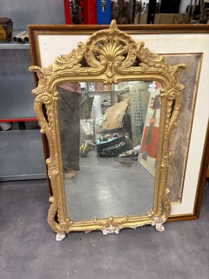 a mirror that is sitting on the floor in front of a shelf