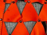 a close up of an orange vest with metal buttons on it