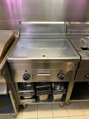 une grande cuisine en inox équipée d'un évier et d'une cuisinière