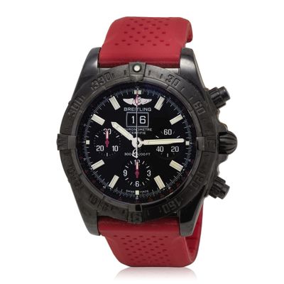 the watch is black and red with a red rubber strap